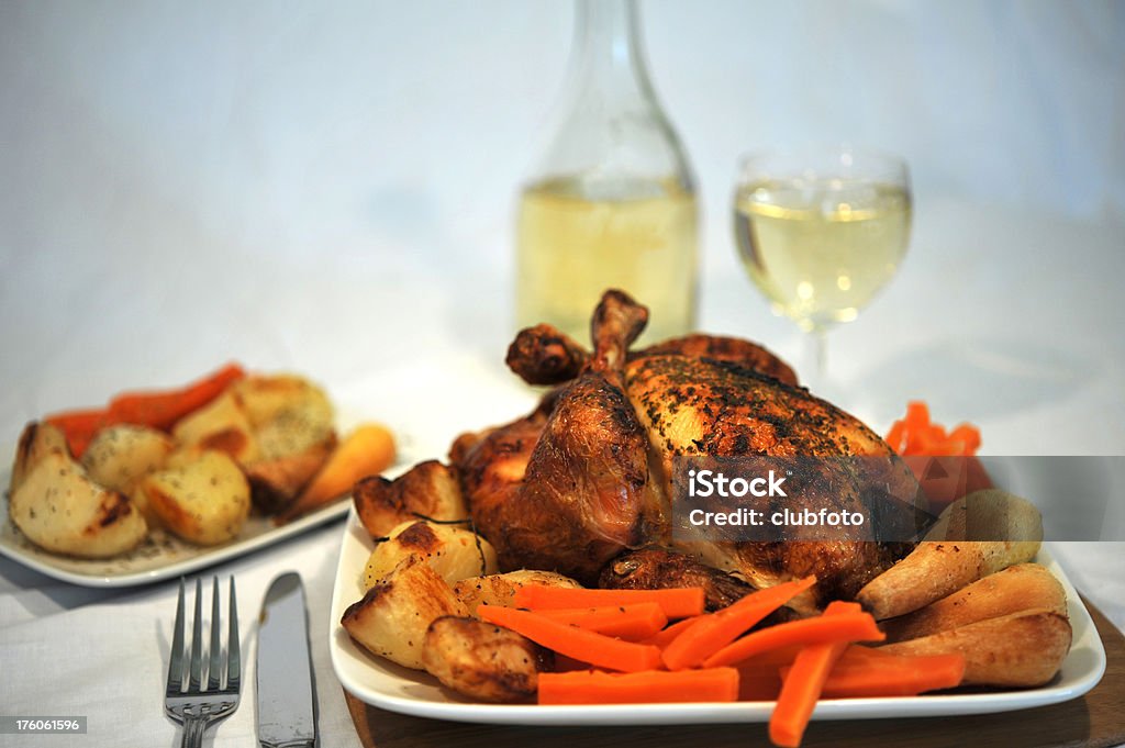 Roasted chicken with roast vegetables and white wine A freshly roasted chicken with roast vegetables and white wine Carrot Stock Photo