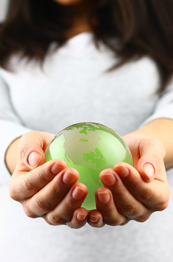 Woman holds a green planet Earth. Symbol of sustainable development and renewable energy