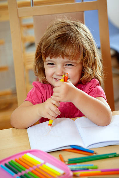 istock Cute girl playing with color pencils 176062684