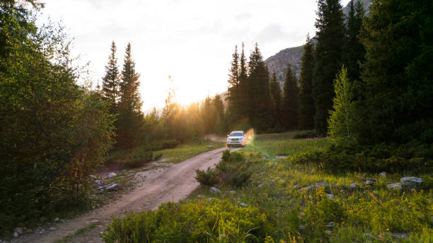 istock The SUV overcomes a mountain route through forest 1760628380