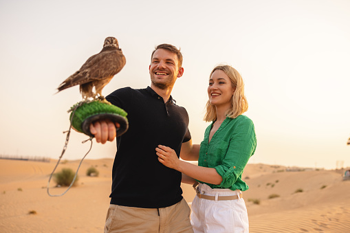 Man handling a falcon and learning about the magnificent bird in Dubai.