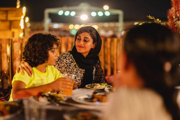Middle Eastern Mother Hugging Her Son At Dinner In Dubai