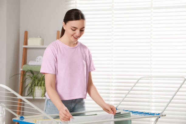 istock Woman hanging different apparel on clothes airer in bathroom 1760644822