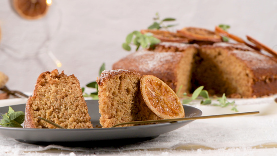 Sliced Christmas orange cake decorated with dried oranges.