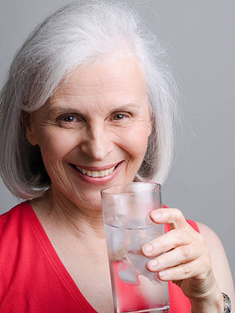 Portrait of Older Woman Holding Ice Water stock photo