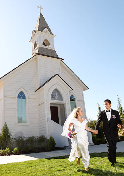 Bride And Groom Standing Amidst Benches In Church