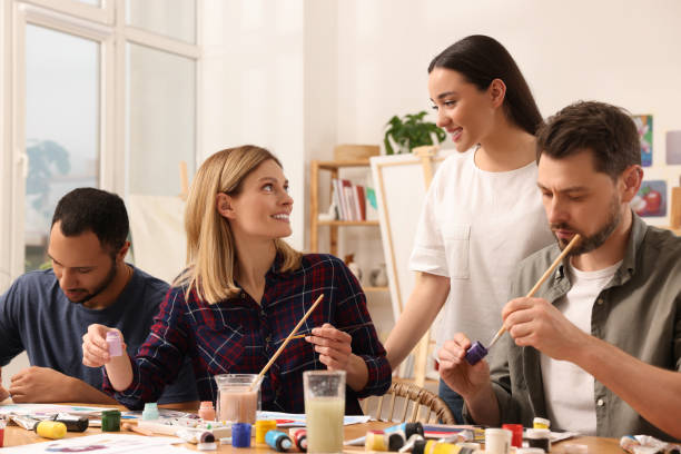 istock Artist teaching her students to paint at table in studio. Creative hobby 1760667307