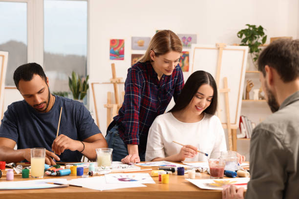 istock Artist teaching her students to paint at table in studio. Creative hobby 1760667856