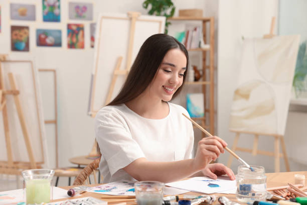 istock Beautiful young woman painting in studio. Creative hobby 1760668504