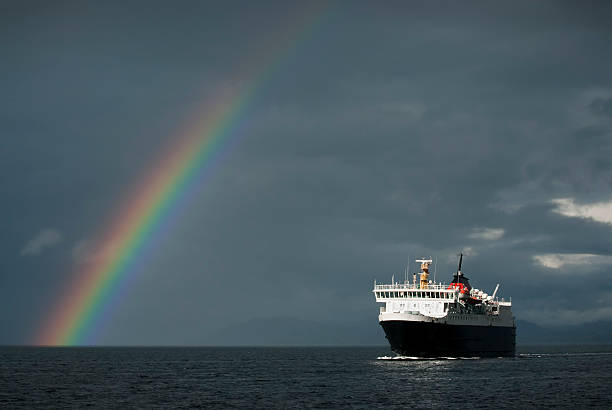 Stormy weather with ferry and rainbow stock photo