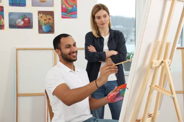istock Artist teaching her student to paint in studio. Creative hobby 1760672496