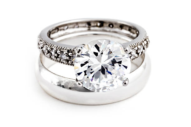 Golden ring with big diamond against jewelry background.