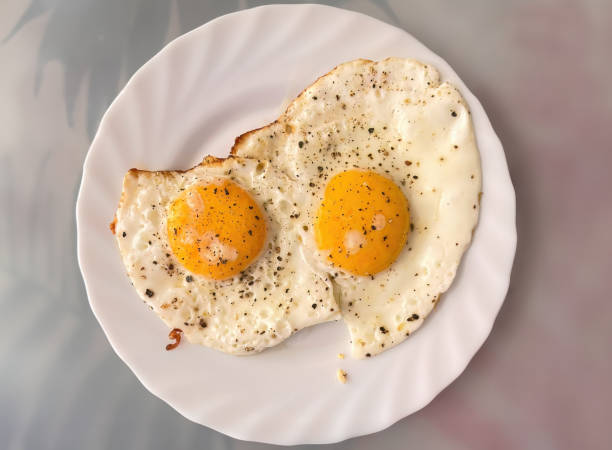 Classic Two Sunny-Side-Up Eggs with Herbs on a White Plate