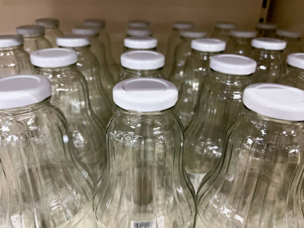 istock Empty Vegetable Juice Glass Bottles with Lids on the Shelf 1760678262