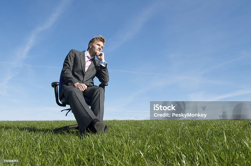 Geschäftsmann sitzt und denkt in Wiese Bürostuhl - Lizenzfrei Abgeschiedenheit Stock-Foto
