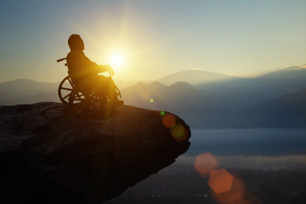 istock Silhouette disability man have a hope on wheelchair look sunset. Challenge and Conquer success International Disability Day and Handicapped Paralympics. Challenge, Conquer and health care concept. 1760686445