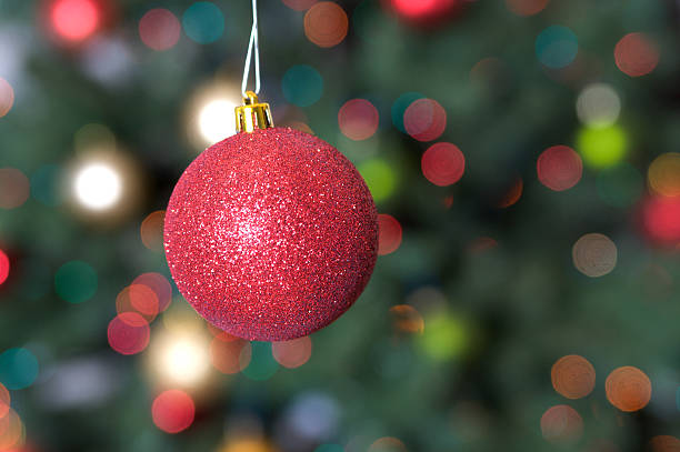 istock Red Glittery Christmas Ornament with Soft Focus Tree Background 176069533