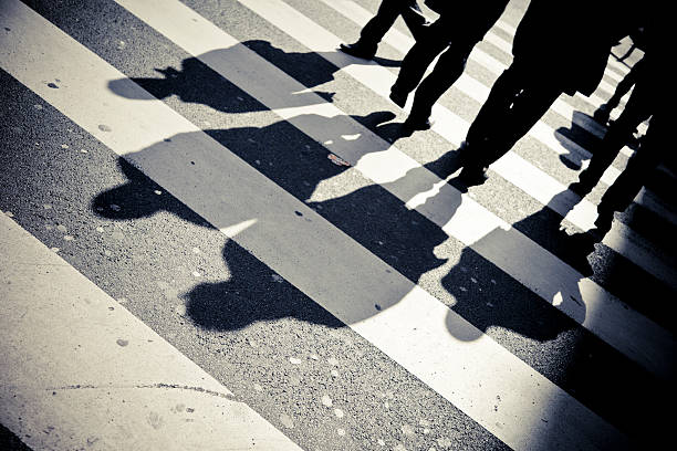 istock Four people's shadows casted across a walkway 176069806