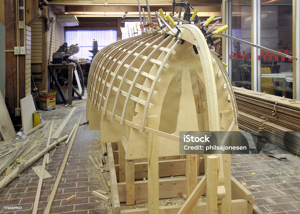 Boat Construction Shop A boat construction shop with a wooden boat bent and glued with clamps. Art And Craft Stock Photo