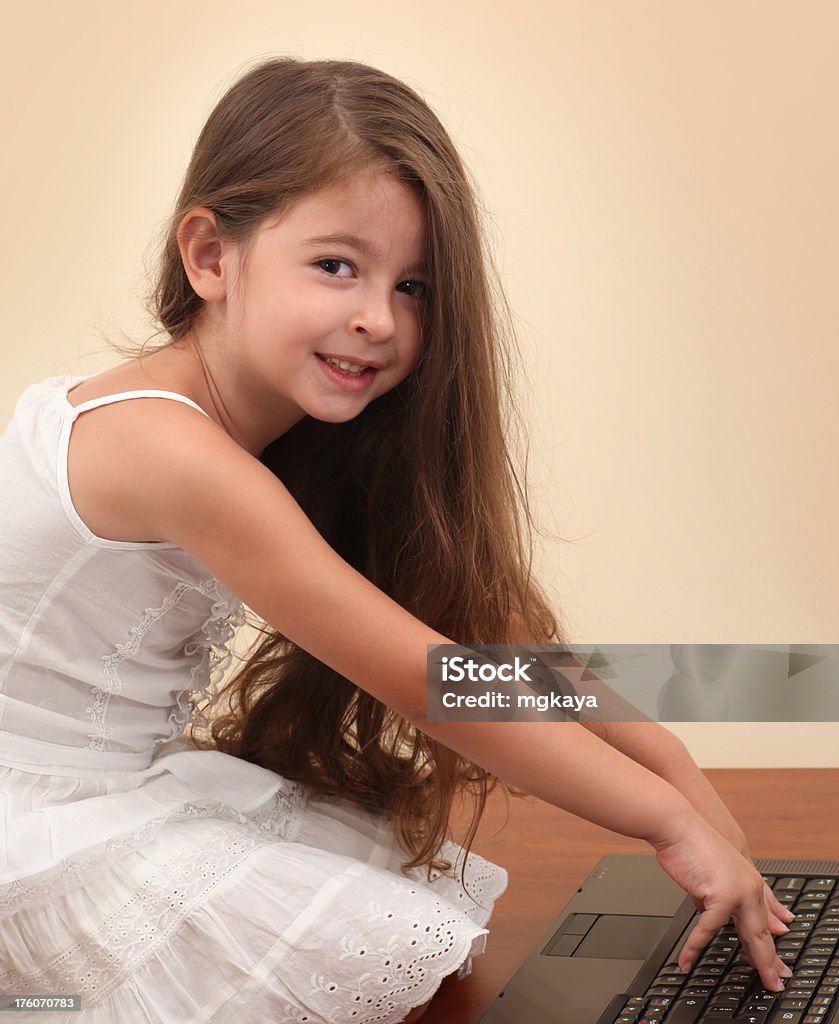 Little Girl Using Computer A cute little girl using computer (laptop) on the floor. 4-5 Years Stock Photo