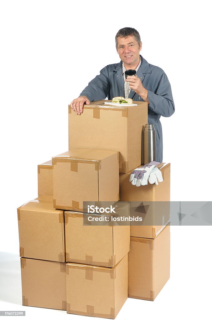 Almacén hombre tener un almuerzo en algunas de las cajas - Foto de stock de 50-59 años libre de derechos