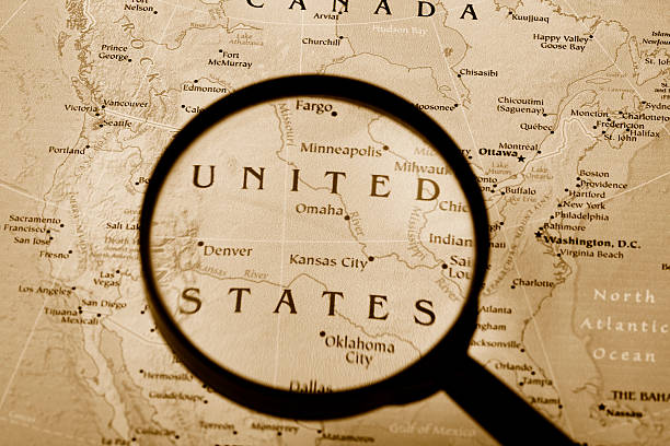 Magnifying glass on vintage retro USA map and currency. Vintage camera on antique America map.