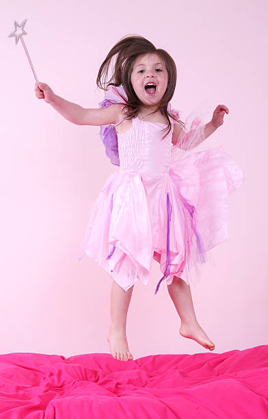 little Princess. Portrait of a cute Caucasian little laughing girl in an evening bright pink dress on a white background. Horizontally. with copy space.