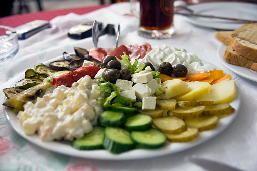 Healthy appetizer plate served at a vacation resort in Southern Europe. Shallow DOF with main focus on olives at center of image.