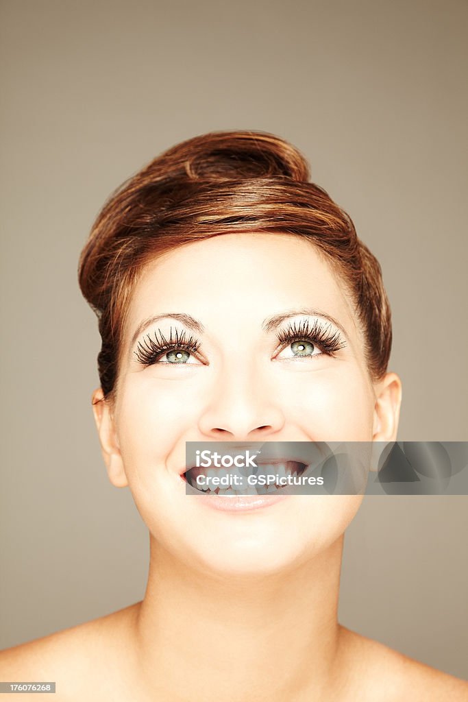 Young Female Model's Headshot A young female model looking up and smiling. Vertically framed shot. 20-29 Years Stock Photo