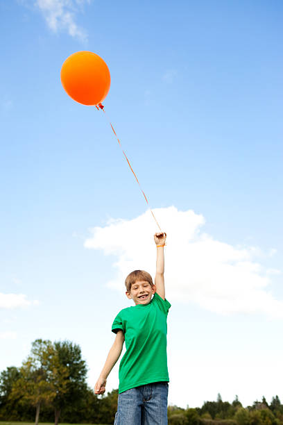 istock Happy Boy Holding Balloon Outside 176077181
