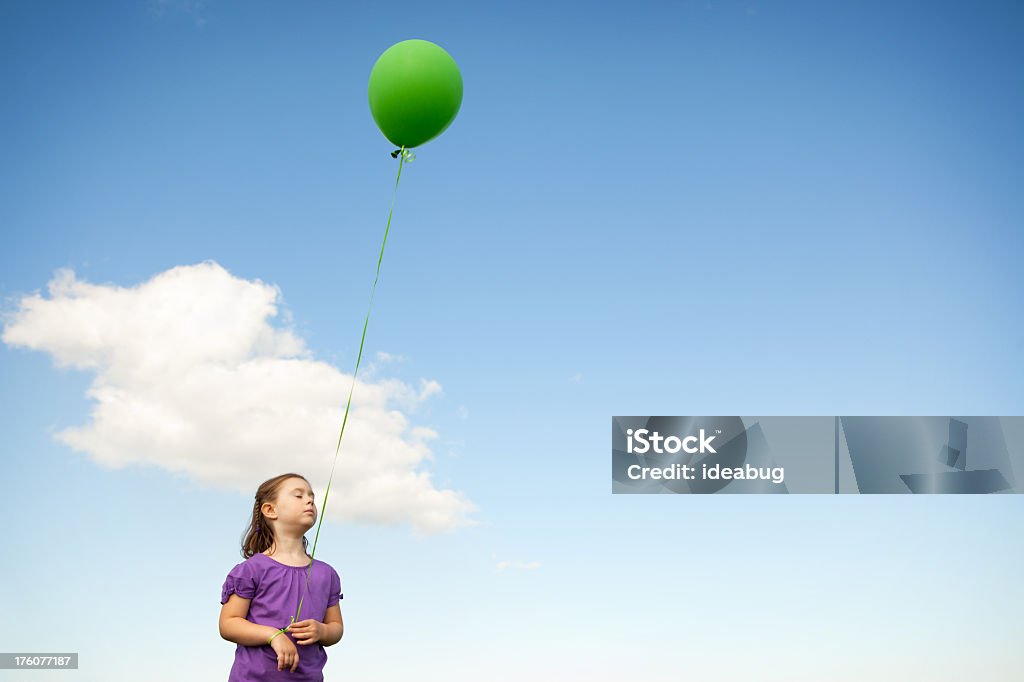 Petite fille tenant un ballon en forme et Rêvasser - Photo de 4-5 ans libre de droits