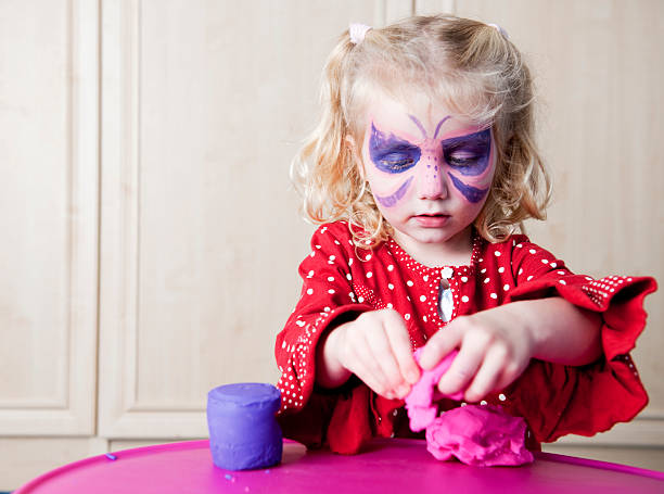 niña jugando con modelado de arcilla - blue eyes flash fotografías e imágenes de stock