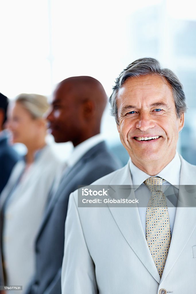 Biznesmen uśmiechając się z kolegami w tle - Zbiór zdjęć royalty-free (40-49 lat)