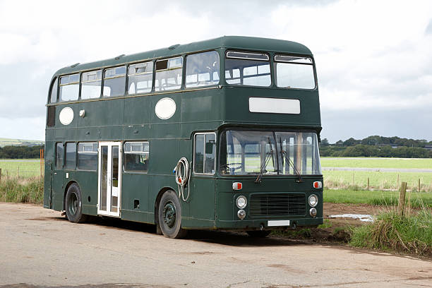 Green double decker bus parked in countryside