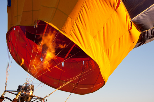 Flames filling a hot air balloon just before lifting off.