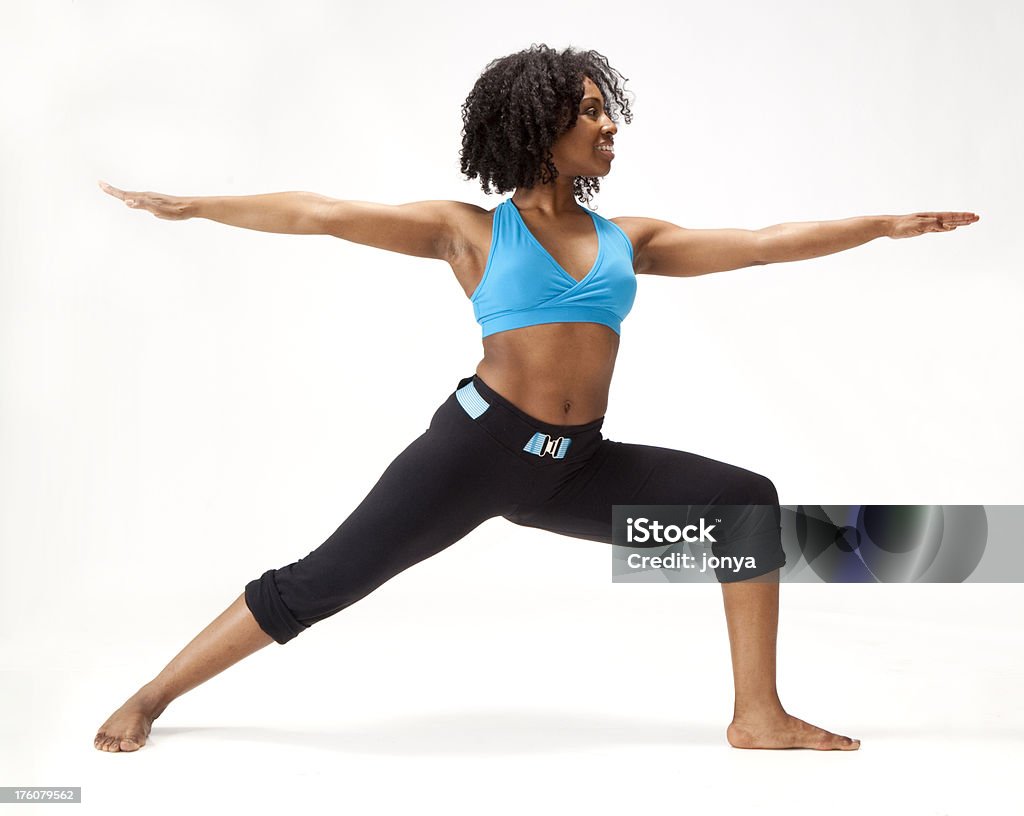 young African-American mujer de yoga virabhadrasana postura - Foto de stock de Fondo blanco libre de derechos