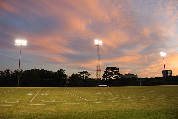 American football field and stadium lights at sunset.