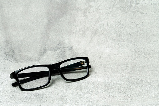 Eyeglasses on a book at cozy modern home kitchen, with a smart phone in the back, representing a healthy lifestyle, wellbeing and mind and body care