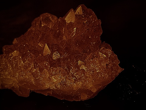 an orange crystal shines in the darkness