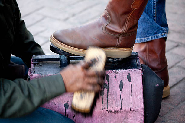 Street Shoeshine Person Shining Leather Boots, Motion Blur A shoeshine person polishes a leather cowboy boot. Slow shutter speed used to produce motion blur on the shoeshine brush. shoe polish stock pictures, royalty-free photos & images