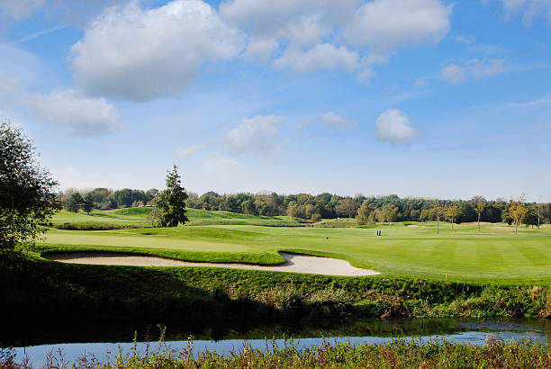 istock Green grass golf course and sand bunker beside river 176084141
