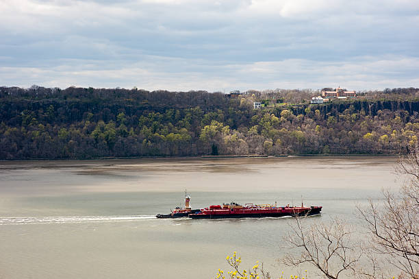 Tugboat pushing an oil tanker up the Hudson River stock photo