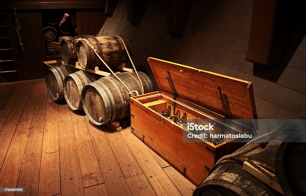 Cellar with barrels Cellar in moody lights with wooden barrels and old glass bottles in a box. Crate Stock Photo