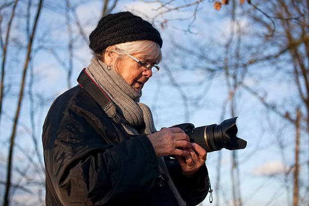 istock Senior woman with digital SLR camera 176086924