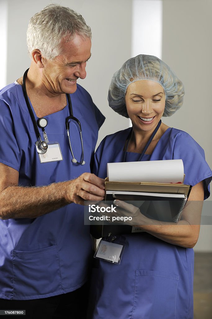 Professionisti medici esaminando un grafico - Foto stock royalty-free di Adulto