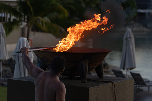 Momi Bay Fiji - September 13 2023; Flames rise against dark of night as lighting of flaming night torches takes place.