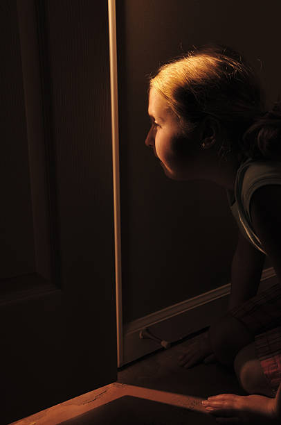 istock Girl peeking through cracked door 176090696