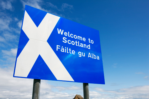 Wide angle shot of the roadsign at the Scottish border that welcomes every traveller. Low angle view. Clear sky and some clouds. Scottish flag. XXXL (Canon Eos 1Ds Mark III)