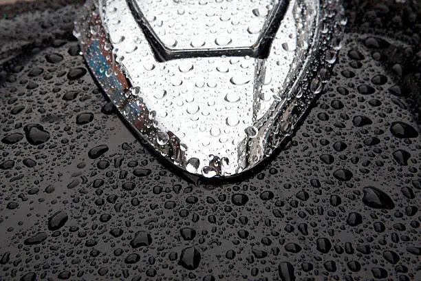 closeup of raindrops on the gas of a black motorcycle