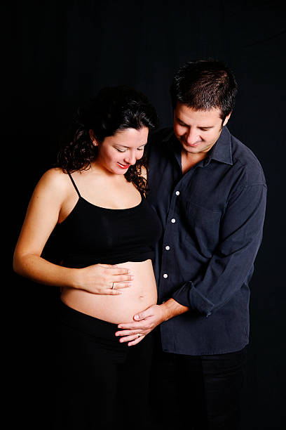 Parents To Be "Young, parents to be couple looking to the baby.For more of my similar images, please follow the banner link below:" 3 months pregnant belly stock pictures, royalty-free photos & images